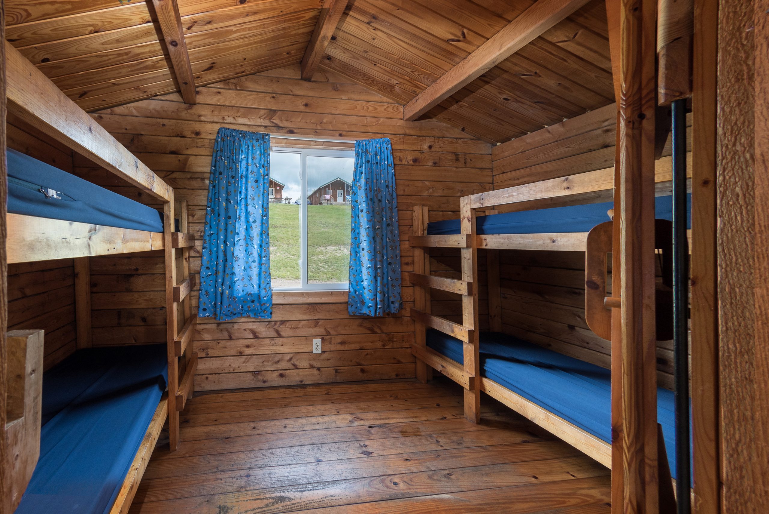 Back Room of rustic cabins, two sets of single bunk beds on the sides