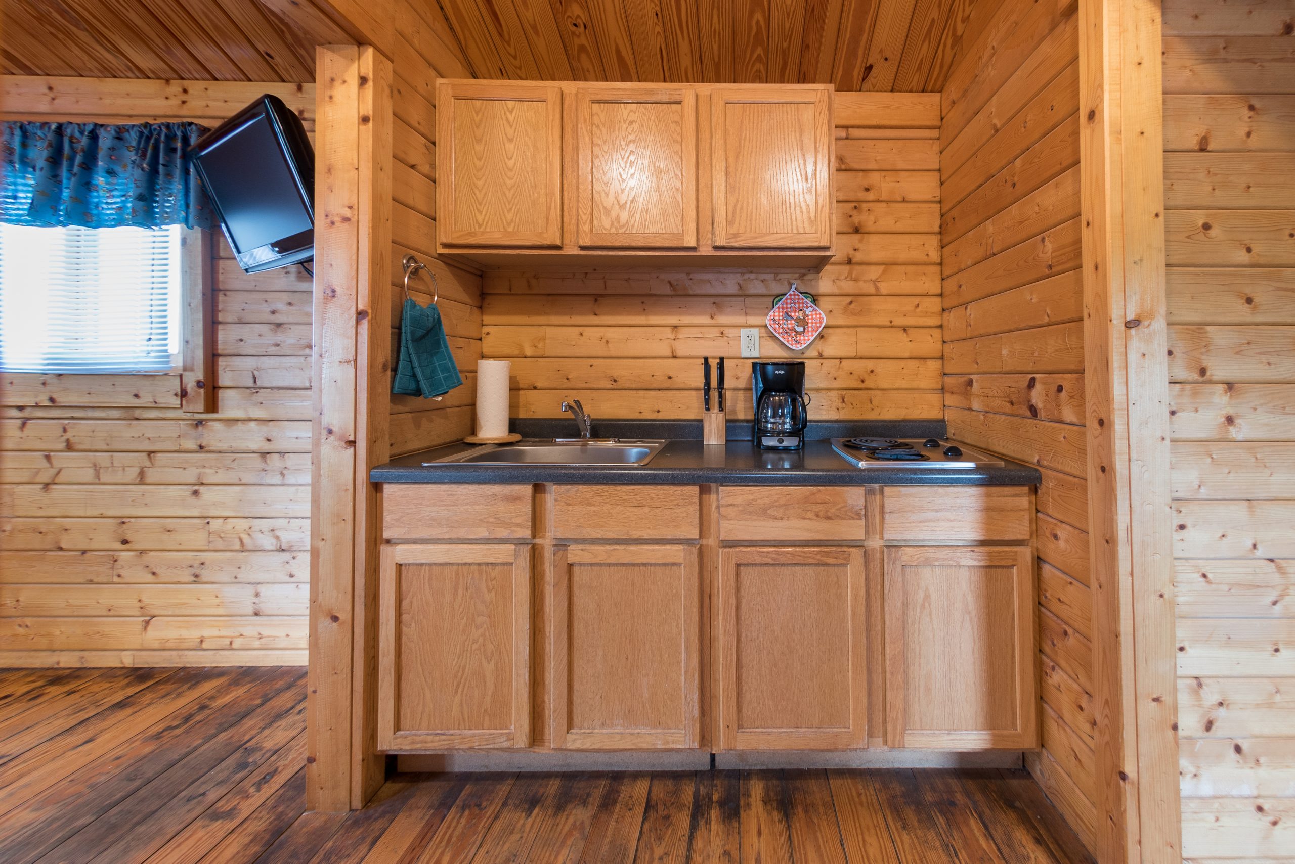 Cottage kitchenette view from bunk room, sink, coffee maker and two burner range